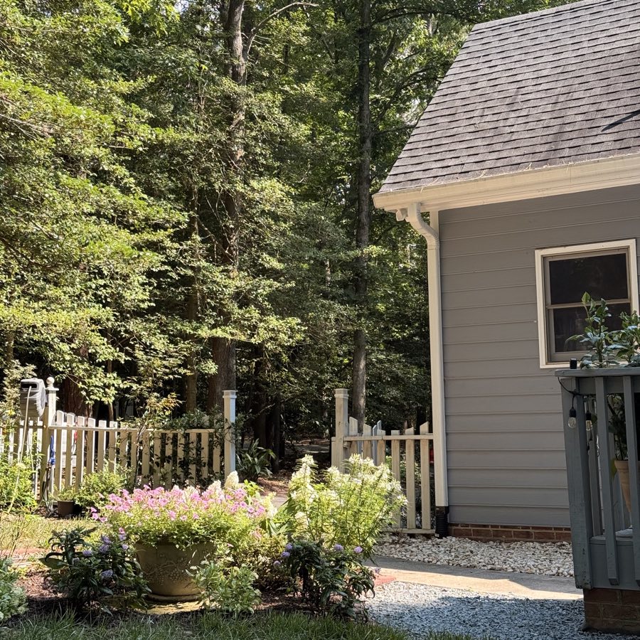 A flower-filled garden beside the house and woodland gate